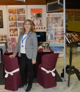 La directora del hotel, Ángela Jiménez Egea, posa delante del stand de la feria EXPOBODA que el periódico IDEAL organiza cada año en el Palacio de Exposiciones y Congresos de Granada.