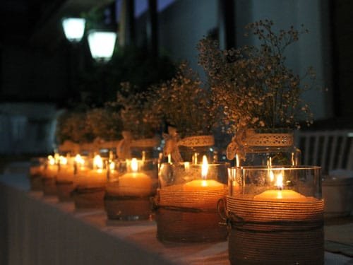 Mesa de celebraciones adornada con velas en la noche